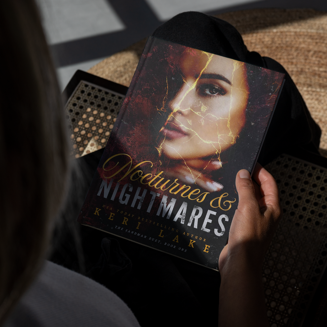 Book titled 'Nocturnes & Nightmares' held by a person with a dark background
